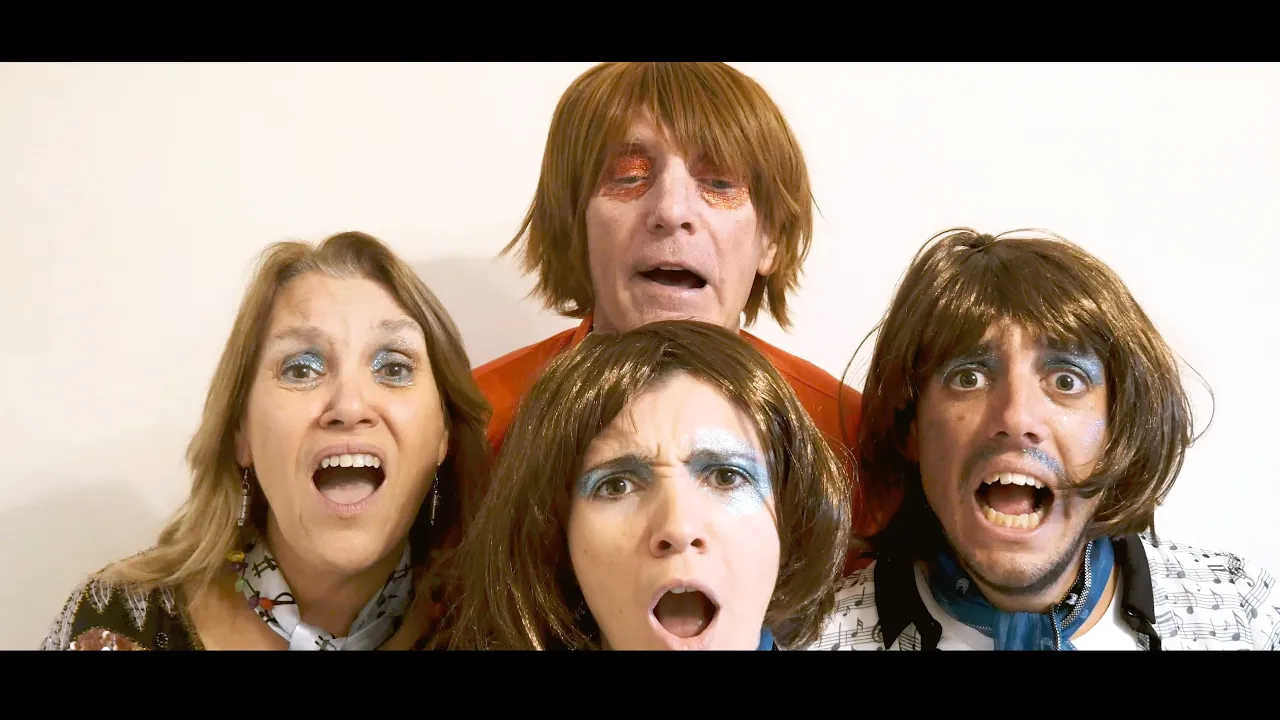 feliz año nuevo abba avisa a la familia Cuatro personas con la cara pintada y pelucas posan dramáticamente, con la boca abierta en expresiones exageradas, como si cantaran un clásico de ABBA sobre un fondo liso. | Jacob Warn